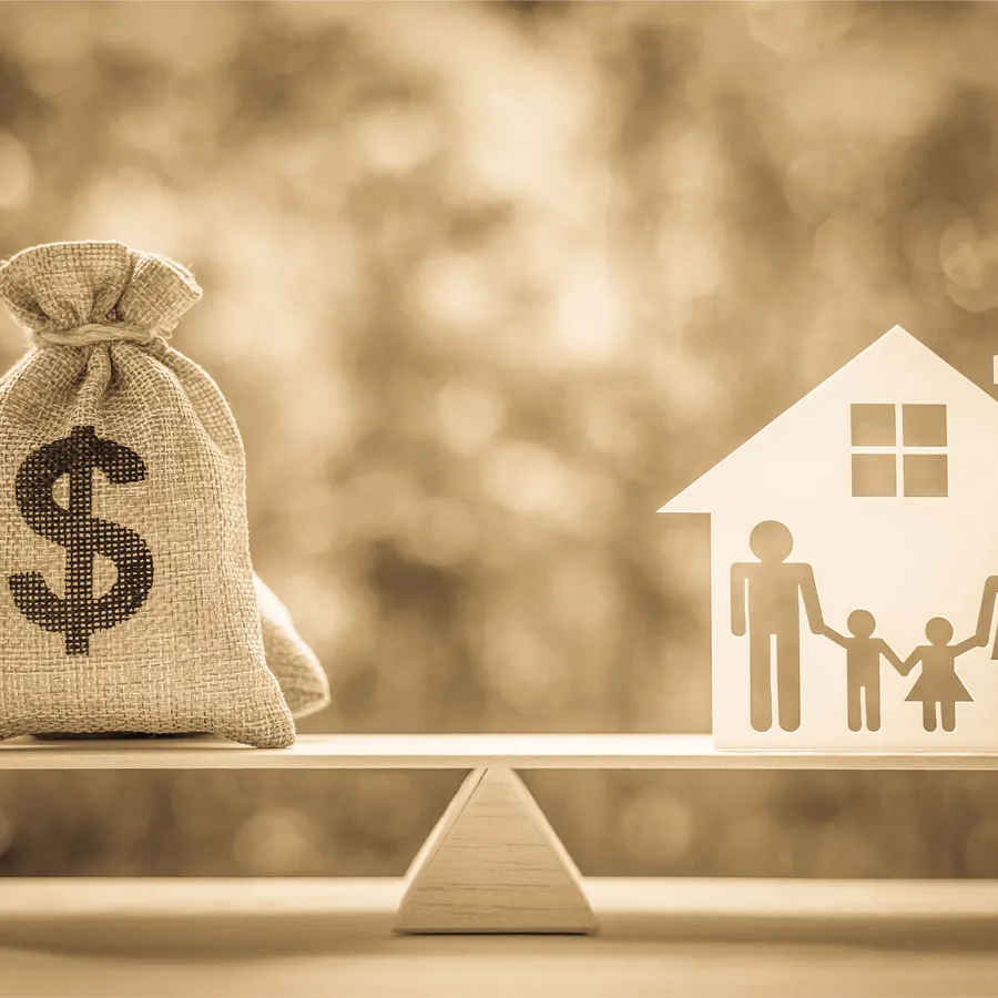 Haus und Familie auf einer Waage